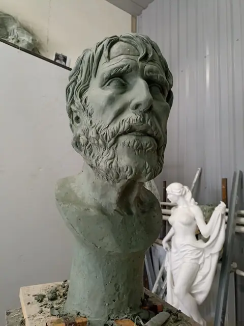 Модель в три четверти, рядом малая скульптура